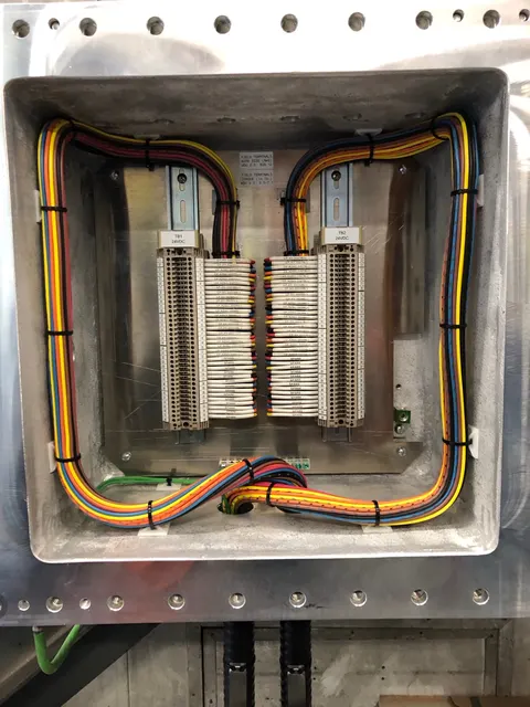 Colored wires neatly routed to two terminal blocks inside an electrical enclosure.