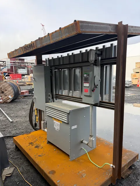Electrical enclosures, a transformer, disconnect switch, and conduit mounted on a steel frame for owner-described temporary power distribution.